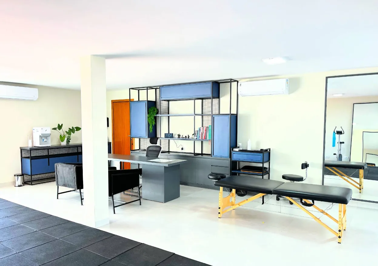 Sala ampla de atendimento com maca e equipamento de avaliação